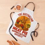 Cotton apron featuring boxing kangaroo in gloves holding meat pie beneath glowing orange outback sunset sky