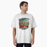 Oversized T-shirt printed with cartoon koala holding hot meat pie on Sydney Opera House steps with blue harbour sky
