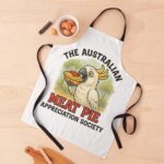Adjustable kitchen apron printed with cartoon cockatoo eating meat pie topped with tomato sauce under eucalyptus bush scene