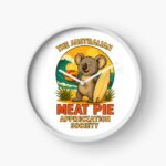 Round wall clock printed with surfing koala holding meat pie, ocean waves and sunset sky